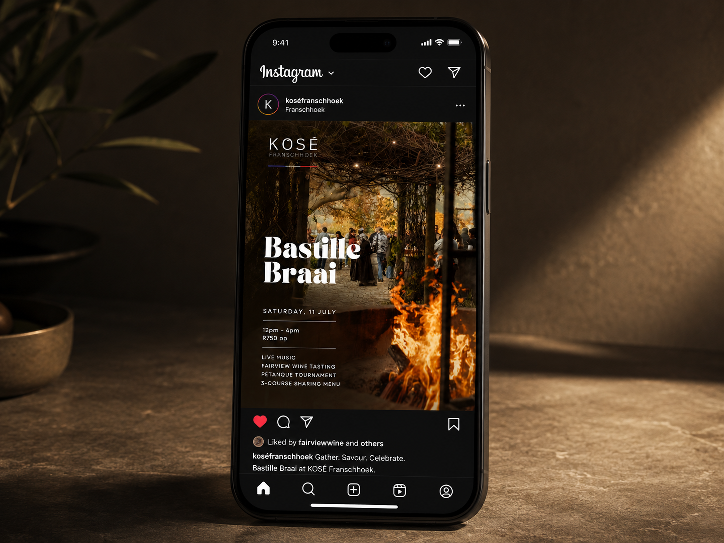 Instagram post mockup for the KOSÉ Bastille Braai event shown on an iPhone against a warm textured backdrop.